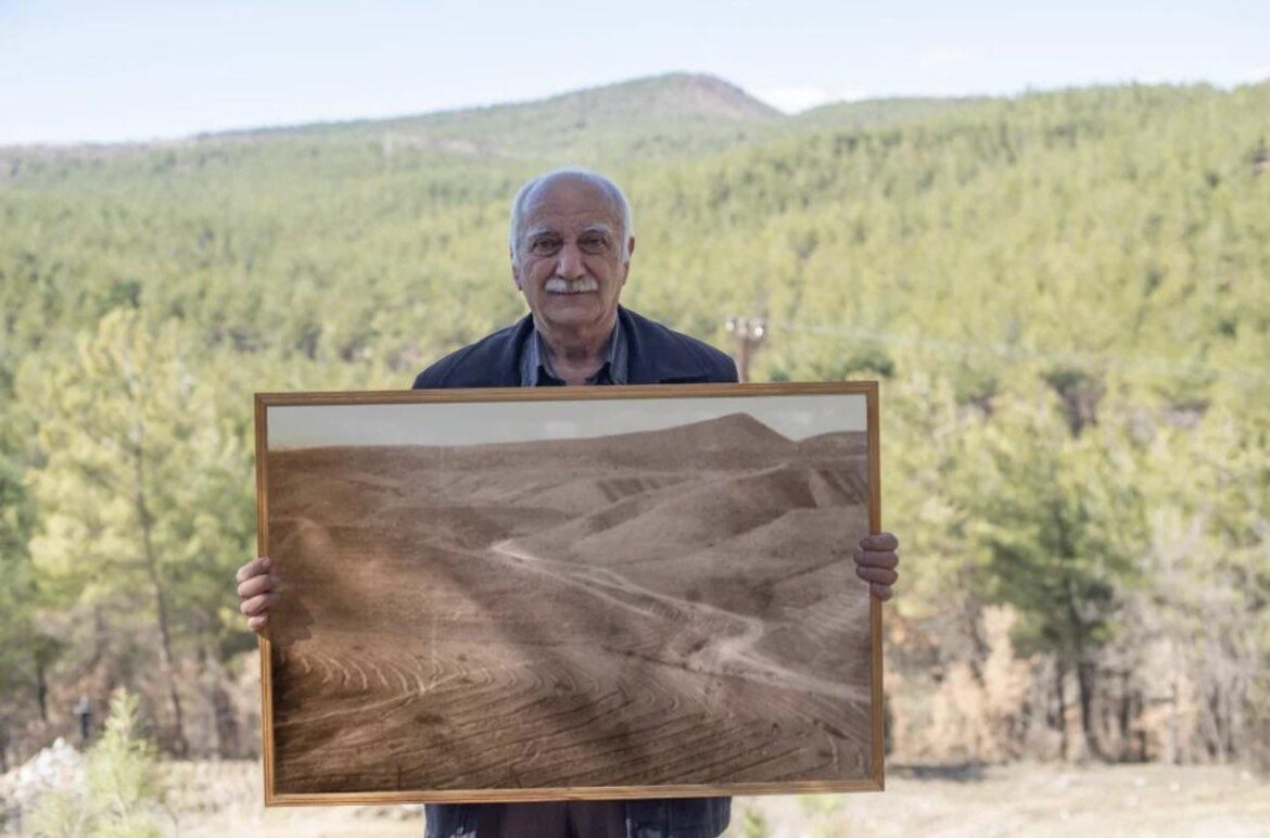 Man poses with photo of forest he helped restore